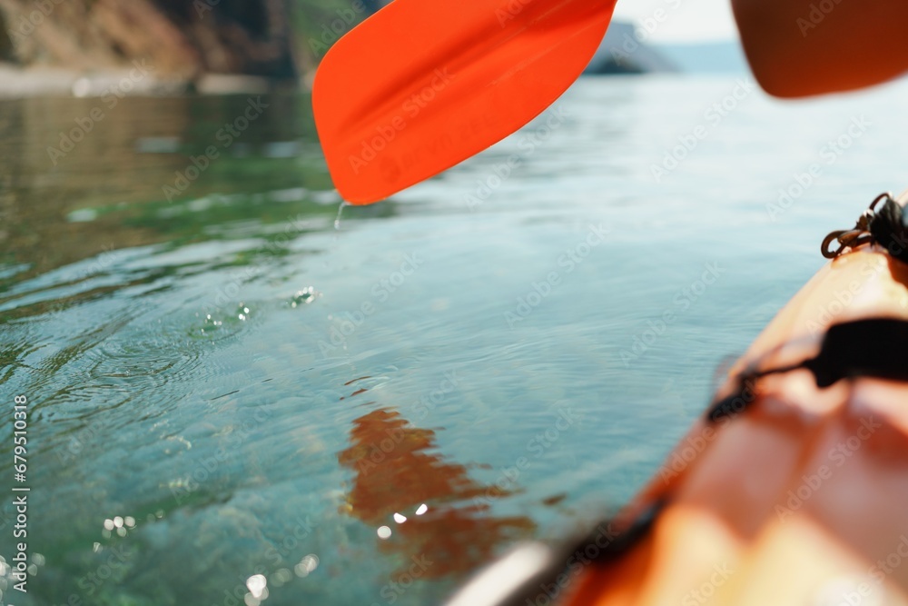 Kayak paddle sea vacation. Person paddles with orange paddle oar on kayak in sea. Leisure active lifestyle recreation activity rest tourism travel Kayak paddle sea vacation. Person paddles with orange paddle oar on kayak in sea. Leisure active lifestyle recreation activity rest tourism travel