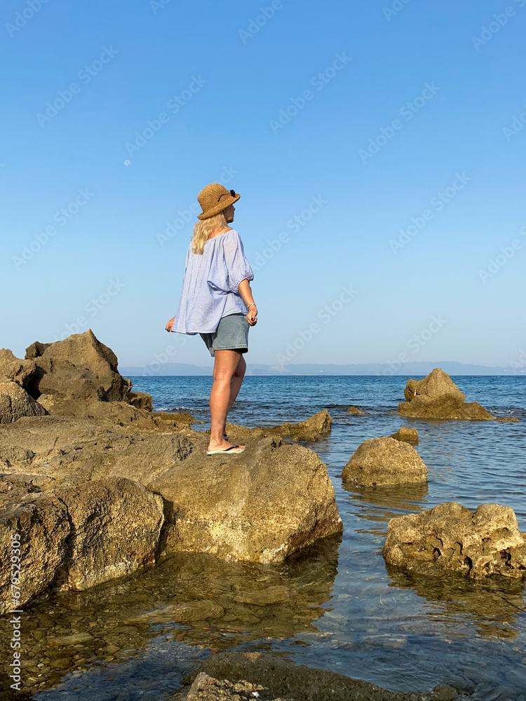 Woman relaxing on rocks by the sea
