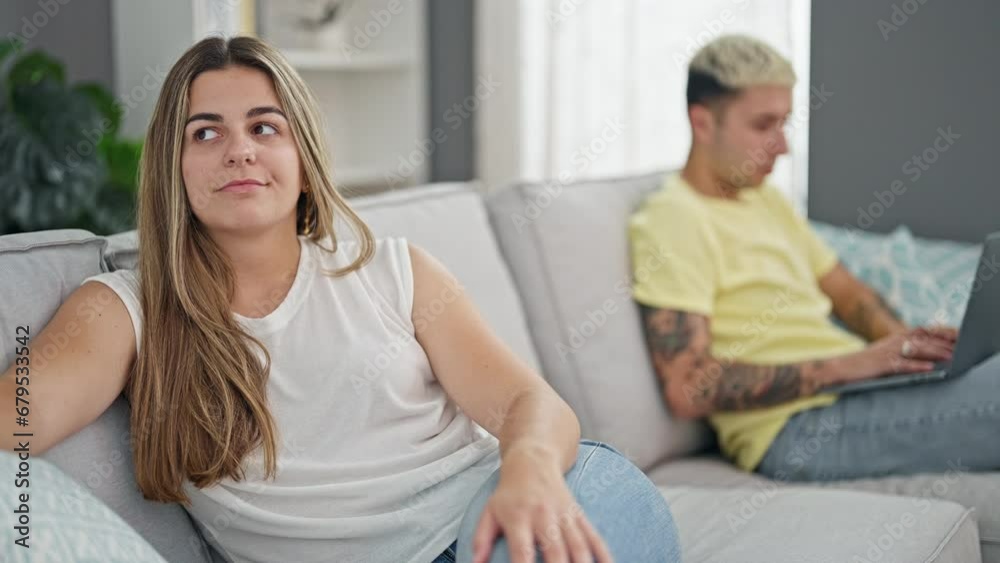 Beautiful couple sitting on sofa using laptop having problems at home Beautiful couple sitting on sofa using laptop having problems at home