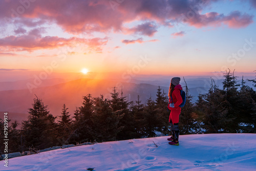 Adult adventurous woman standing on top of a snow peak. Winter Wonderland. . Aerial landscape from Beskydy mountain, Czech republic. Lysa mounta