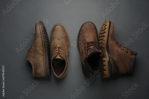 Leather boots and brogue shoes on a dark gray background. Top view photo