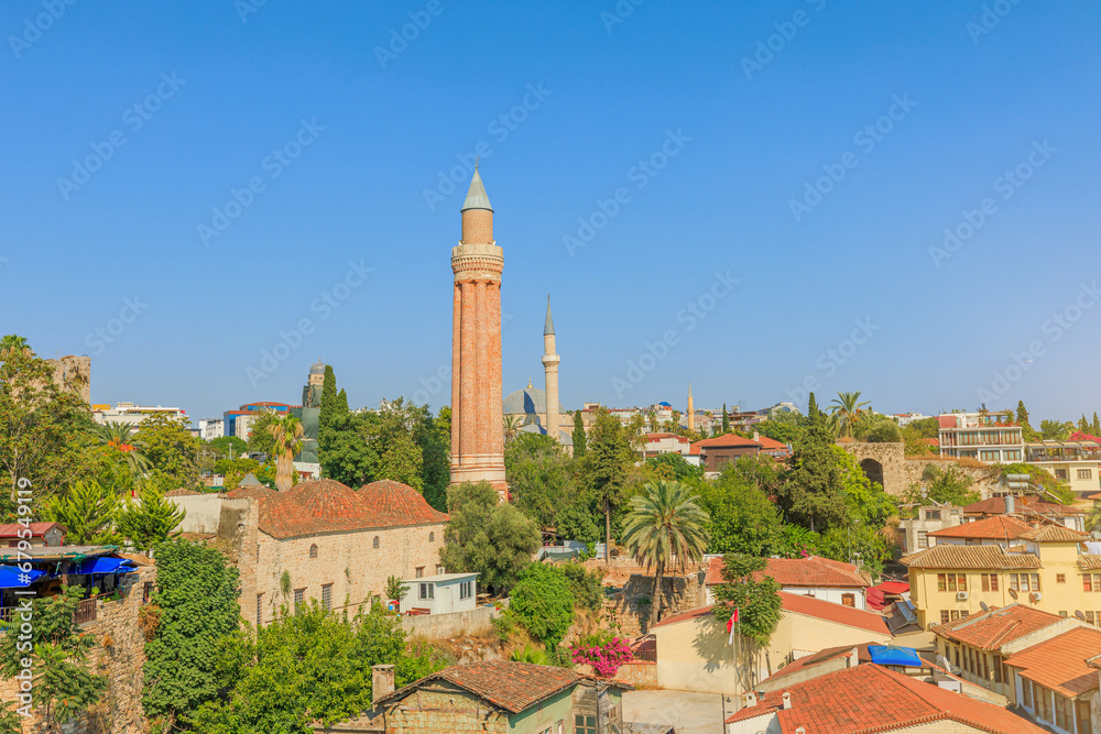 Antalya cityscape , Turkey, with a mosque and its distinct minarets as the focal point. The minarets, crafted from red brick, display intricate designs. Architectural charm of this coastal city.