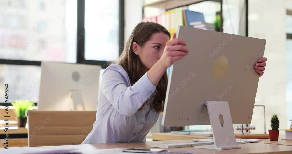 Businesswoman screams hysterically and cracks computer monitor in office
