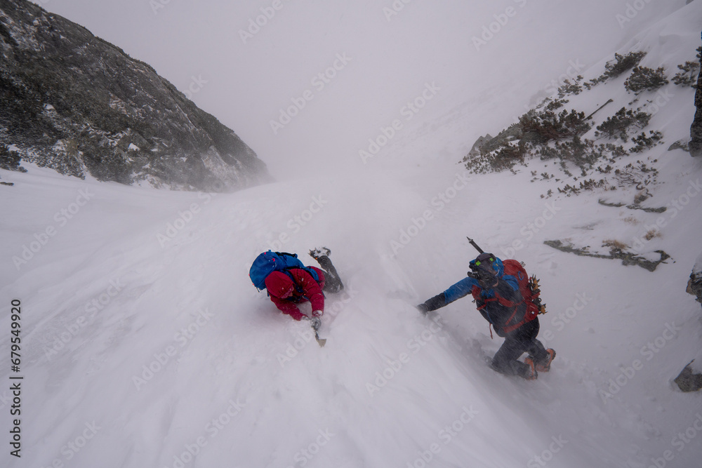 Men with backpack hiking on mountain in snow. Fight for survival in winter mountains. Hiker standing on top of a mountain. Dramatic scenery. Carpathian, Tatras , Europe. Beauty world.