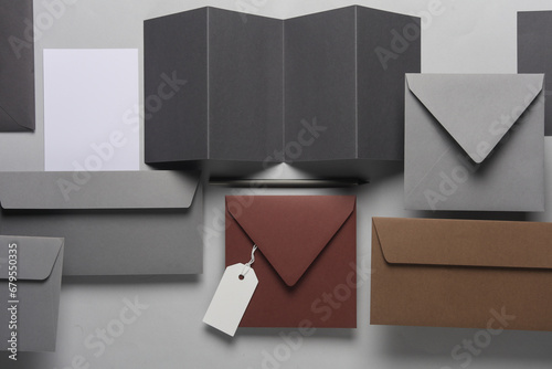 Floating envelopes and brochure, cards, tag on gray background with shadow. Minimalism, modern business still life, creative layout