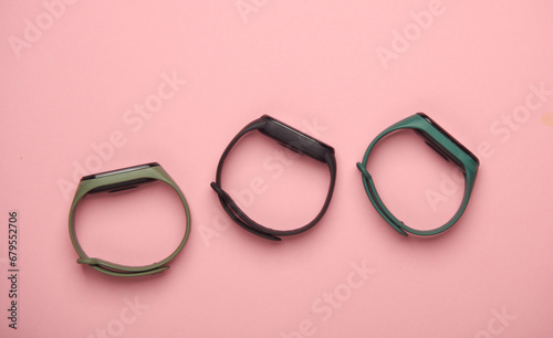 Three smart bracelets on a pink background