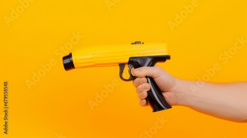 Man holds a refueling gun in his hand for refueling cars isolated on yellow background. Gas station with diesel and gasoline fuel close-up