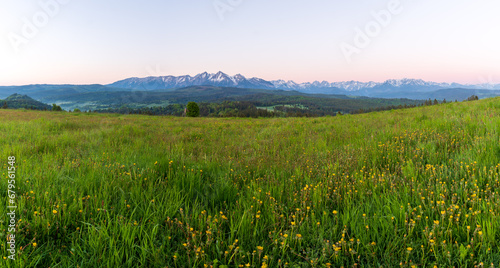 Beautiful sunset with dramatic sky at golden hour over green fields and farms in poland tatras mountain in polsko