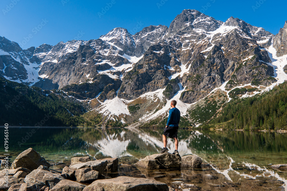 Man tourists in mountains at Morskie Oko lake near Zakopane, Tatra Mountains, Poland.