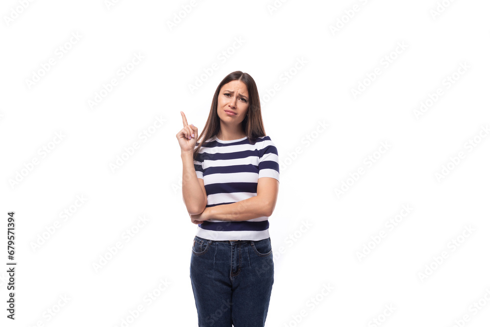 young european lady with black even hair dressed in a striped t-shirt points with her index finger for ideas and news