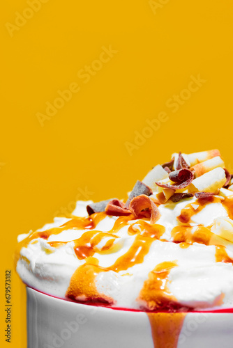 Close-up of delicious sweet drink with whipped cream and caramel toppings against yellow background. Concept of winter season, Christmas holidays, traditional drinks, taste. Poster