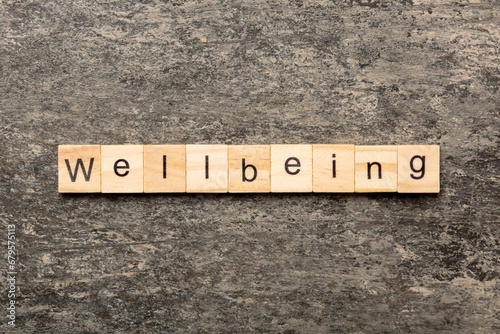 Wellbeing word written on wood block. Wellbeing text on cement table for your desing, concept