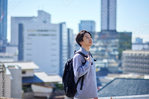 リュックを背負った日本人大学生と町並み photo