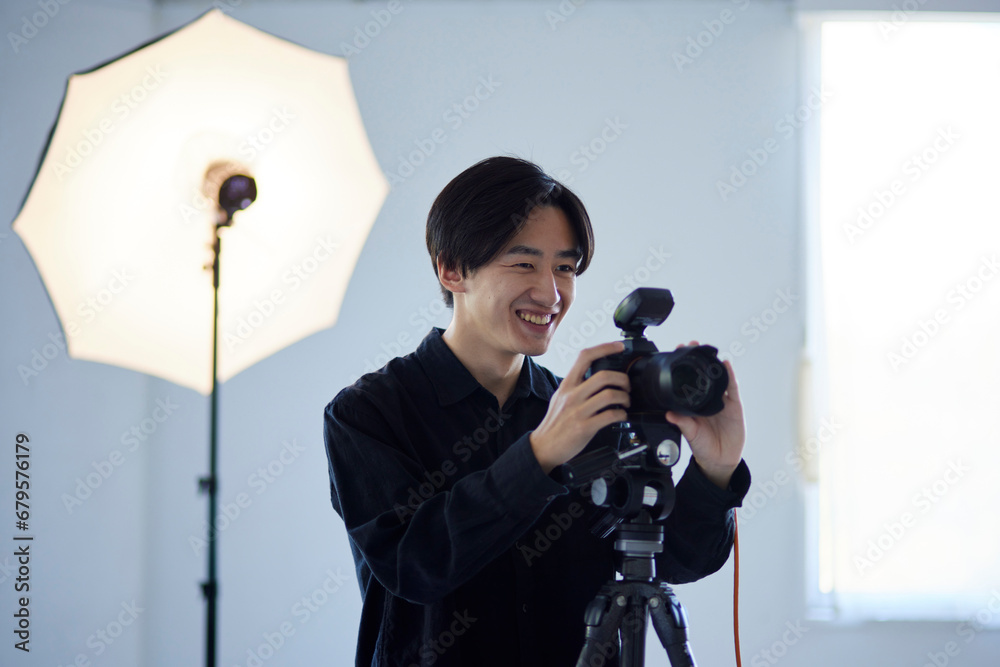 Obraz premium 写真スタジオにて撮影を行う日本人カメラマンの男性