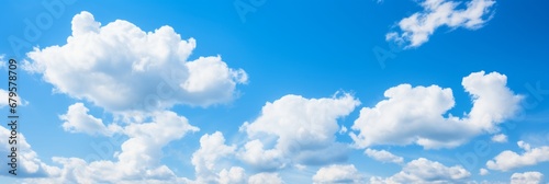 Vibrant blue sky with fluffy white clouds forming a picturesque and serene natural background © Ilja