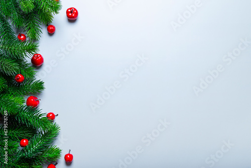 Christmas card with copy space - fir branches and red New Year decorations on a light blue background