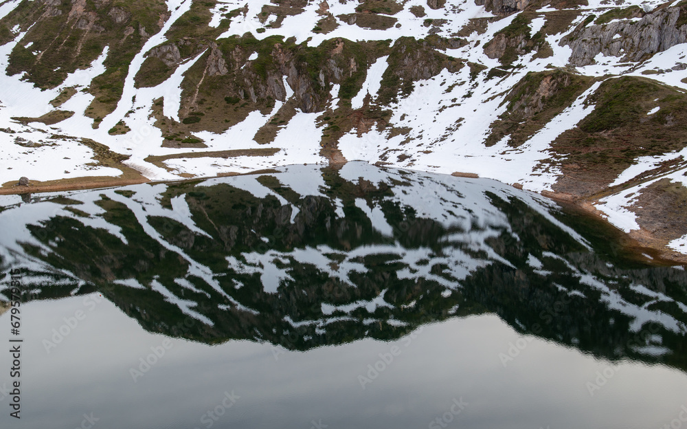 Snowy slope reflected in a lake