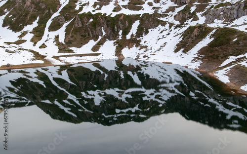 Snowy slope reflected in a lake