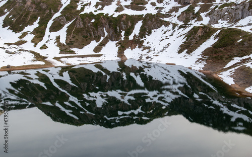 Obraz na płótnie Snowy slope reflected in a lake w salonie