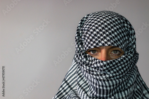 Green-eyed woman wearing a Palestinian scarf. Conflict concept photo