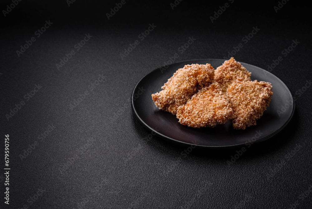 Delicious fresh crispy chicken nuggets on a dark concrete background Delicious fresh crispy chicken nuggets on a dark concrete background
