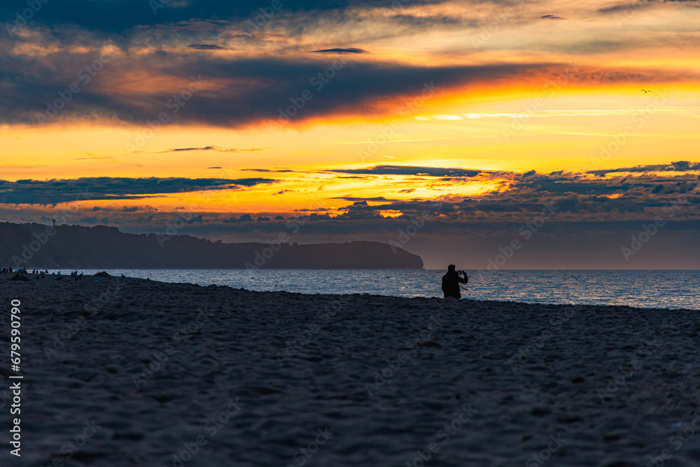 Beautiful dark golden sunset at golden hour at the beach next to dark and cold sea at summer right after the storm and rain