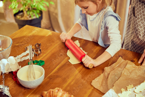 Top view image with baking items on kitchen table. Little girl, child cooking with her mother, baking croissants and cookies. Concept of cookie day, motherhood, childhood, holidays, family