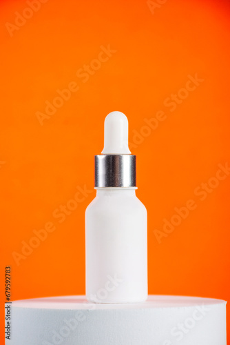 Plastic white tube for cream or lotion. Skin care or sunscreen cosmetic with stylish props on orange background 