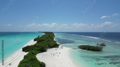 Mangrove vegetation and long white sand beach amid sky blue water of Dhigurah Island photo