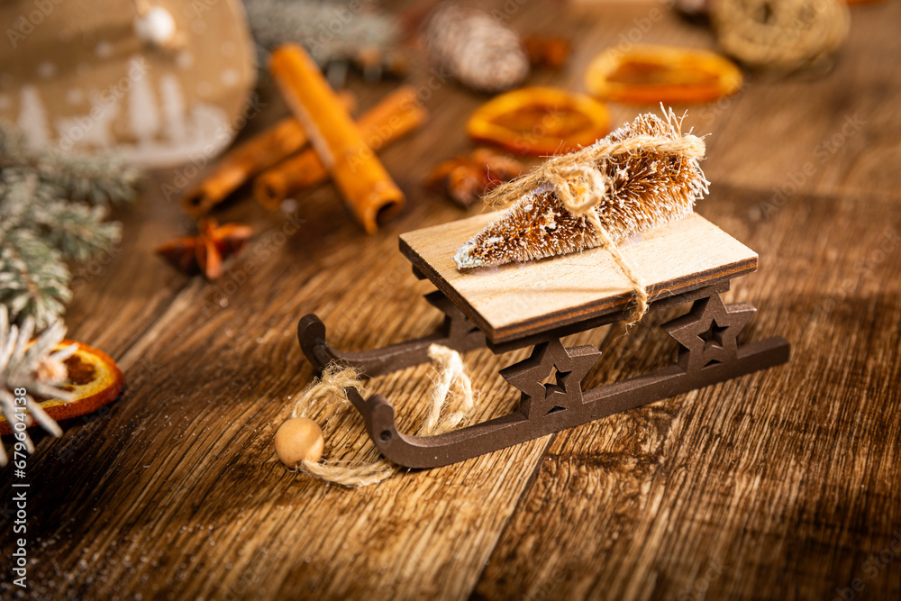 Christmas sleigh with a Christmas tree in the main plan and cinnamon and dried orange in the background. Christmas sleigh with a Christmas tree in the main plan and cinnamon and dried orange in the background.