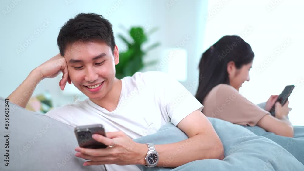 Couple stay together in living room, couple chatting on smartphone while living together. Couple stay together in living room, couple chatting on smartphone while living together.