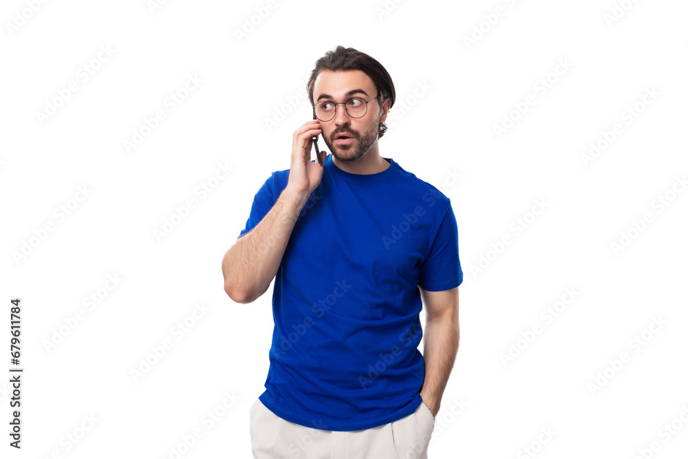 young brunette European man with a well-groomed beard speaks on the phone young brunette European man with a well-groomed beard speaks on the phone