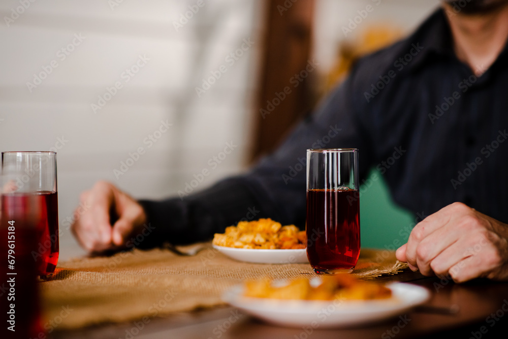 Close up shot of adult man eating italian macaroni with sauce on kitchen table. Christian male thanksgiving before have lunch alone. Christmas family dining Close up shot of adult man eating italian macaroni with sauce on kitchen table. Christian male thanksgiving before have lunch alone. Christmas family dining