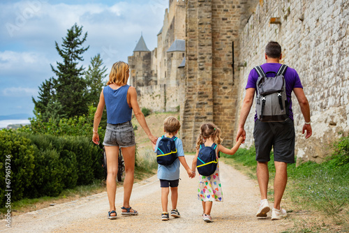 Slika na platnu Tourist family with kids enjoy walk along ancient castle walls