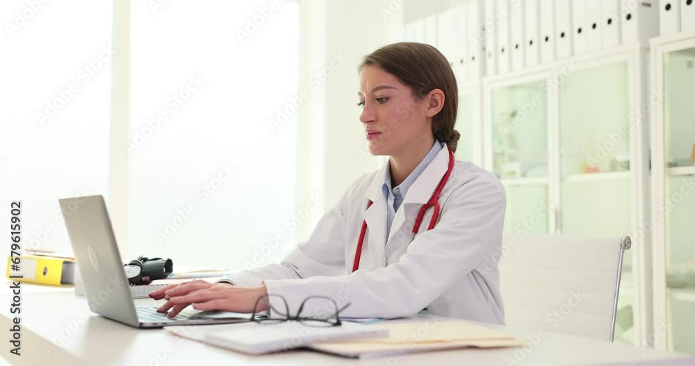 General practitioner in hospital uses laptop computer to print prescription General practitioner in hospital uses laptop computer to print prescription