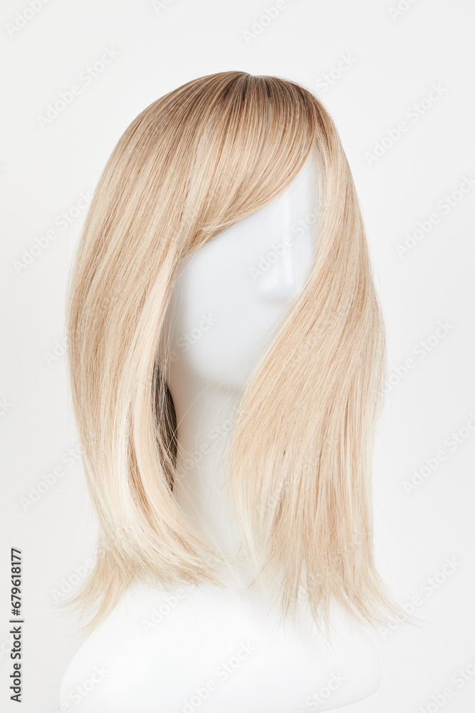 Natural looking blonde fair wig on white mannequin head. Middle length hair cut on the plastic wig holder isolated on white background. Natural looking blonde fair wig on white mannequin head. Middle length hair cut on the plastic wig holder isolated on white background.