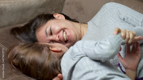 Happy mother and cute little daughter tickling laughing having fun photo