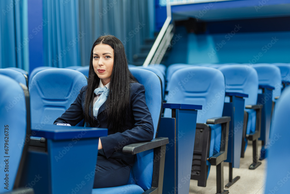 Beautiful brunette university student sitting in the conference room alone for the advertisement photo shoot Beautiful brunette university student sitting in the conference room alone for the advertisement photo shoot