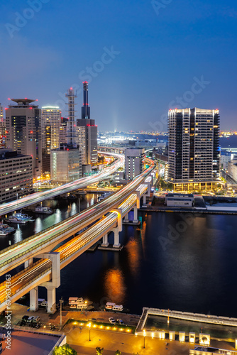 Kobe skyline from above with port and elevated road portrait format at twilight in Japan