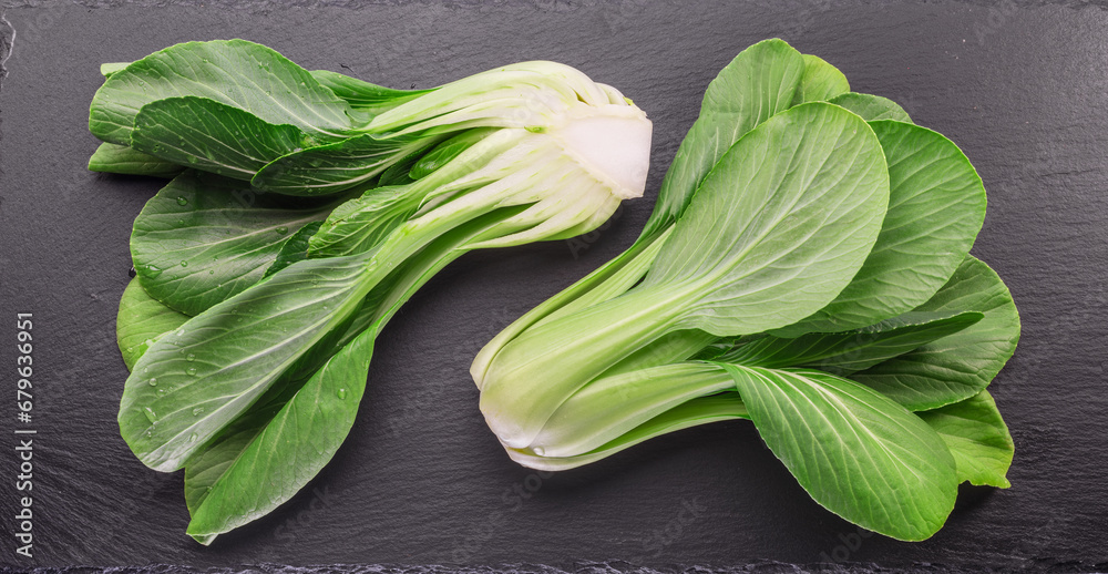 Fresh bok choy or chinese cabbage on slate stone cutting board. Top view. - obrazy, fototapety, plakaty 