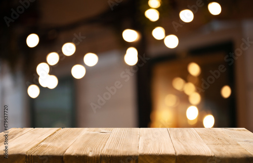 empty wooden table to showcase your product on blurred golden bokeh cafe background