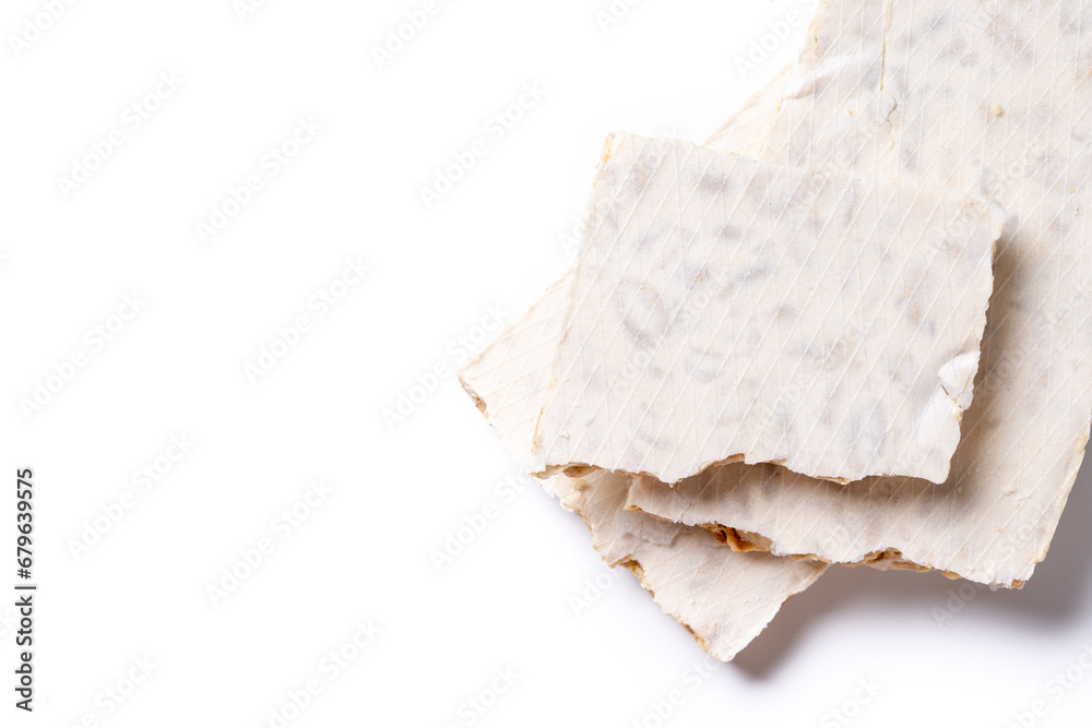 Traditional Christmas sweet, pieces of delicious almond nougat isolated on white background