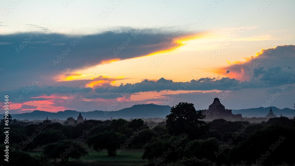 Scenic sunset over the lush woods and ancient temples in Bagan region, Myanmar