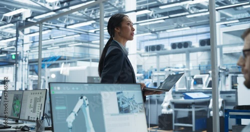 Wallpaper Mural System Administrator Working on a Desktop Computer at a Modern Manufacturing Plant. Focus Switching to a Female Software Developer Programming the Work of the Robotic Arms on Assembly Conveyor Torontodigital.ca
