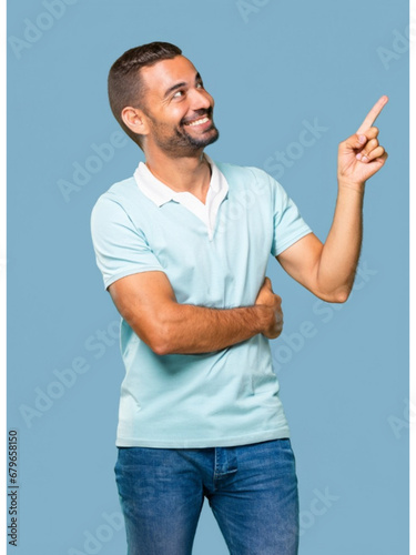 A handsome middle-aged man, isolated on an empty blue background, with a smile, positive and confident expression, pointing his finger to the side, showing an idea, a concept, a success