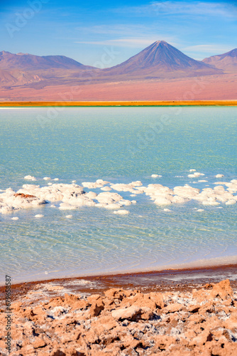 Laguna Tebenquiche, um lago de sal com cores vibrantes azul, verde e amarela ao lado do vulcão Licancabur.   photo