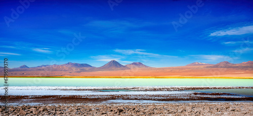 Laguna Tebenquiche, um lago de sal com cores vibrantes azul, verde e amarela ao lado do vulcão Licancabur.   photo