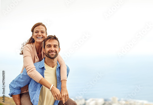 Couple, piggy back and smile in portrait, outdoors and vacation or holiday, date and bonding for love. Happy people, play and fun on trip, travel and connection in marriage, support and trust or face