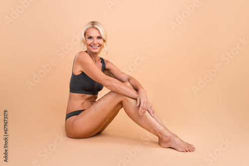 Photo of gentle attractive pensioner lady touch legs enjoy smooth skin after depilation isolated pastel color background