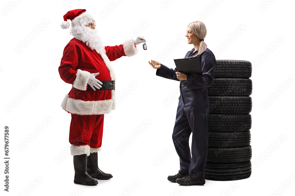 Full length profile shot of santa claus giving car keys to a female auto mechanic